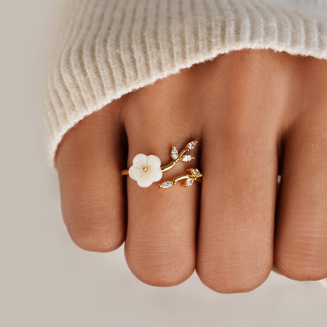 Anillo Dorado con Flor Blanca y Detalles Brillantes